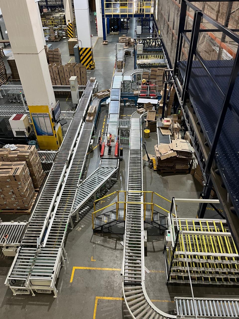 Conveyor lines, curves and transfer points with control cabinets and an access platform