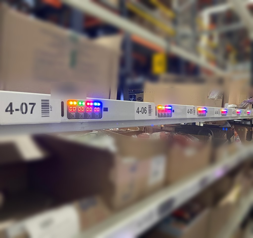 Pick-to-light modules lit at the pick face, with printed location labels