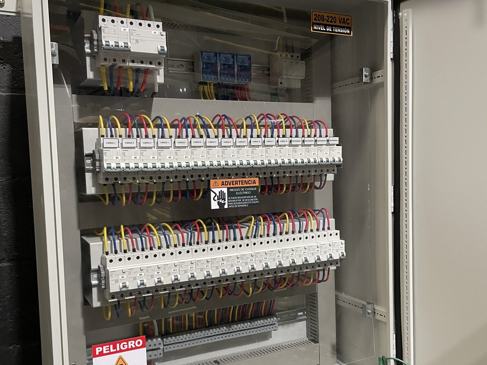 Electrical distribution cabinet with labelled circuit breakers and colour-coded wiring