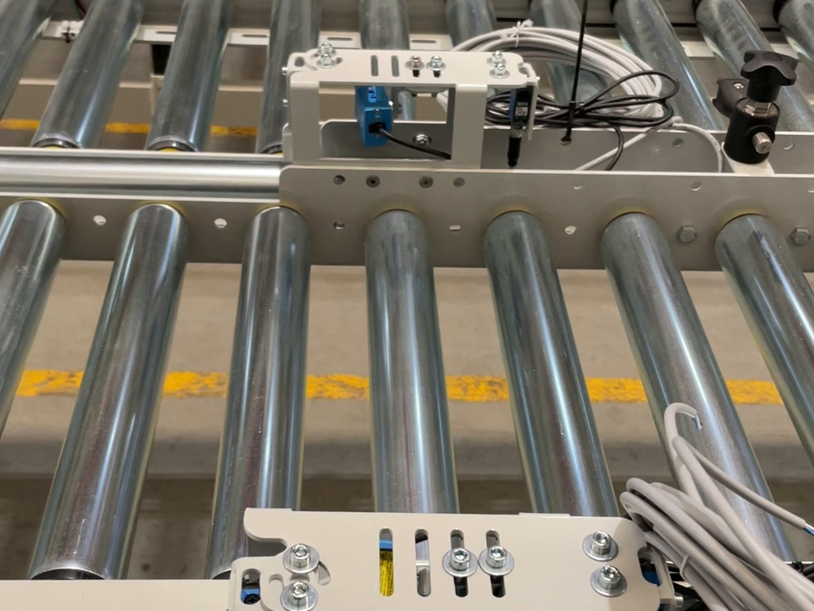 Conveyor-control units and photoelectric sensors mounted on a roller conveyor